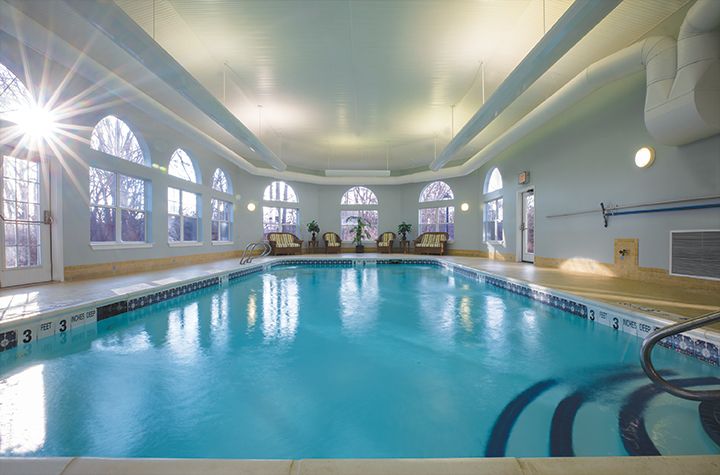 A luxurious indoor swimming pool with elegant architecture and ambient lighting.
