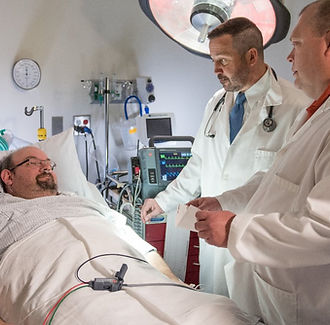 Doctors discussing treatment options with a patient in a hospital setting.