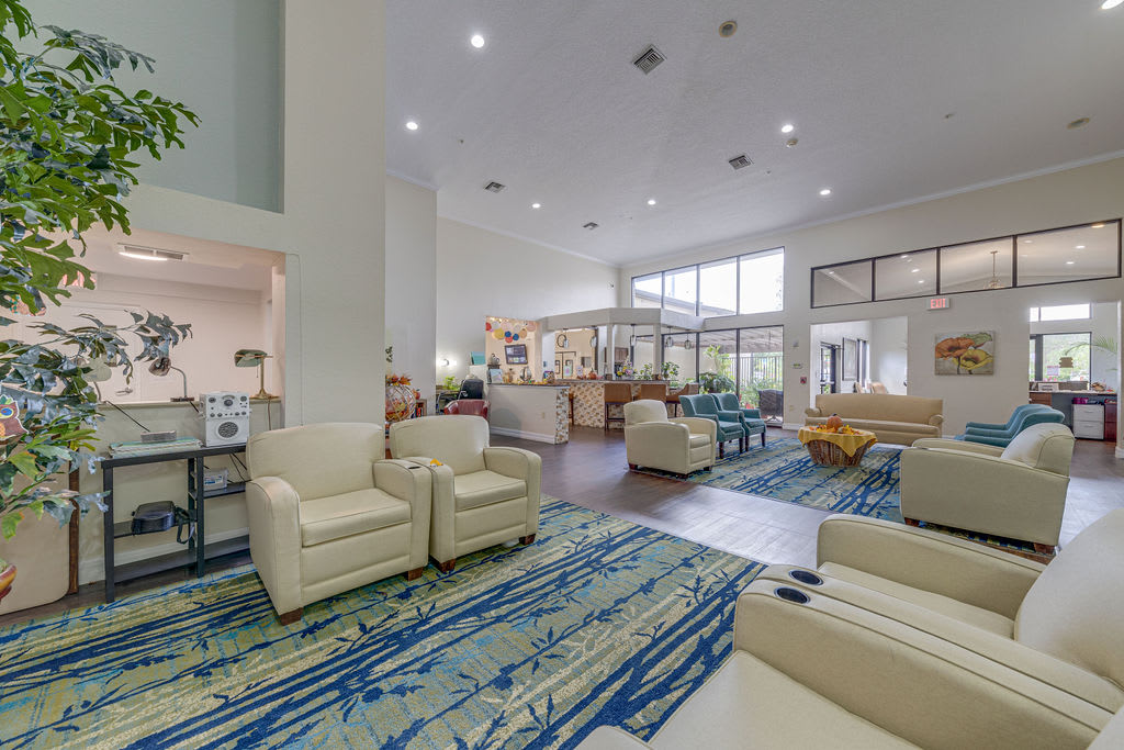 A spacious lobby with modern furniture, featuring a seating area and a reception desk.