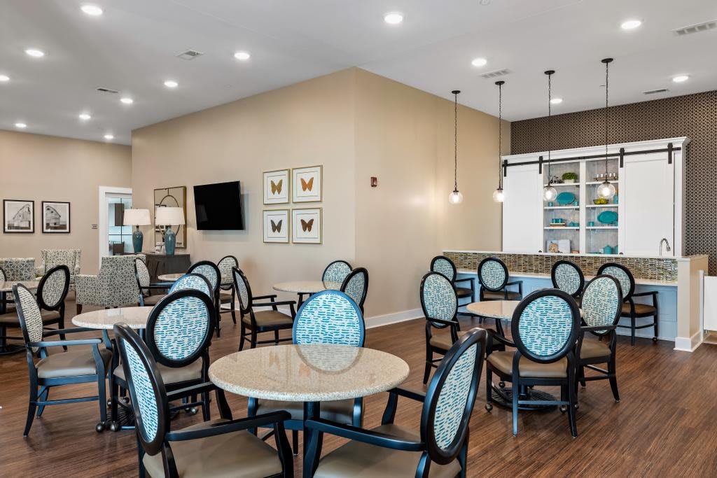 A modern dining area with neatly arranged tables and chairs, featuring stylish lighting and decor.