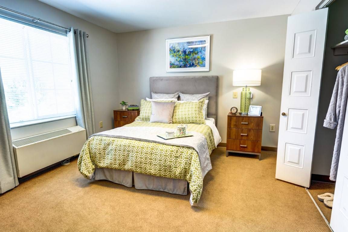A cozy bedroom with a neatly made bed, nightstands, and soft lighting.