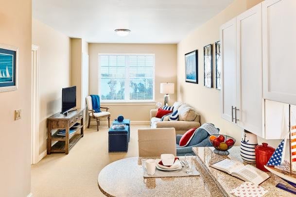 A cozy and well-decorated living room with light-colored walls, a comfortable sofa, and modern furnishings.