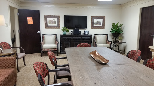 A well-furnished meeting room equipped with a television and comfortable seating.