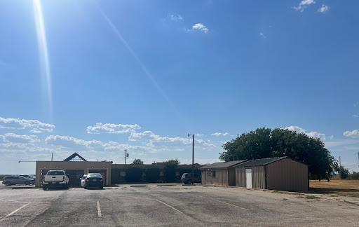 A sunny day at a quiet parking lot with clear skies and scattered clouds.