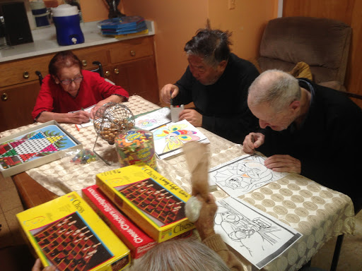 A group of three people engaged in coloring activities at a table.