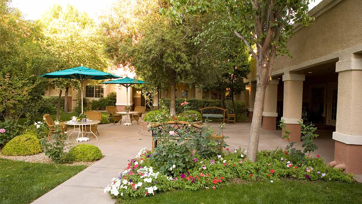 A serene garden with outdoor seating and vibrant flowers.