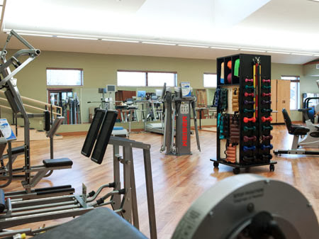 A well-equipped gym featuring various exercise equipment and a spacious workout area.