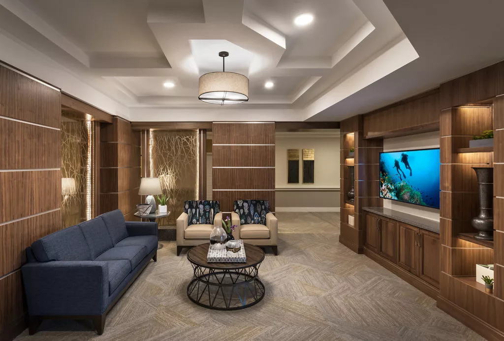 A modern living room with elegant furniture and a built-in aquarium.