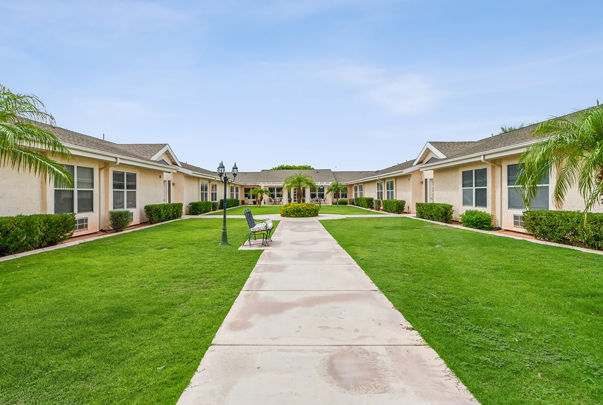 A scenic courtyard with a central pathway leading between adjacent buildings.