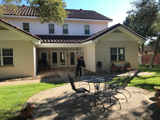 A sunny day in a backyard featuring a comfortable patio area.