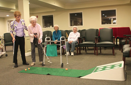 Seniors enjoying a fun indoor golfing activity, promoting social interaction and recreation.