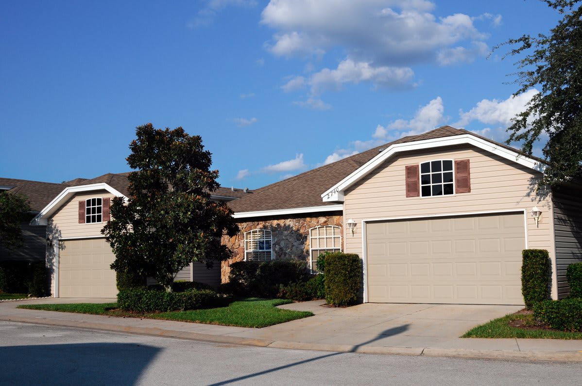 A suburban house with a driveway and garage under a cloudy sky.