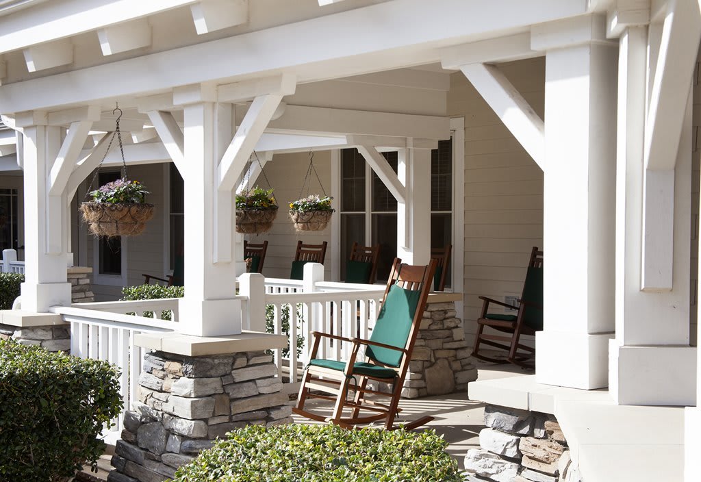 A cozy porch with wooden rocking chairs and hanging plants.