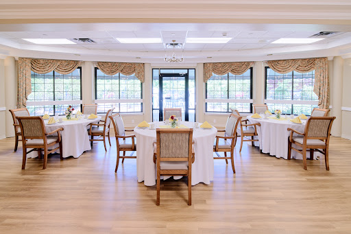 A beautifully arranged dining area featuring elegant tables and chairs, bathed in natural light.