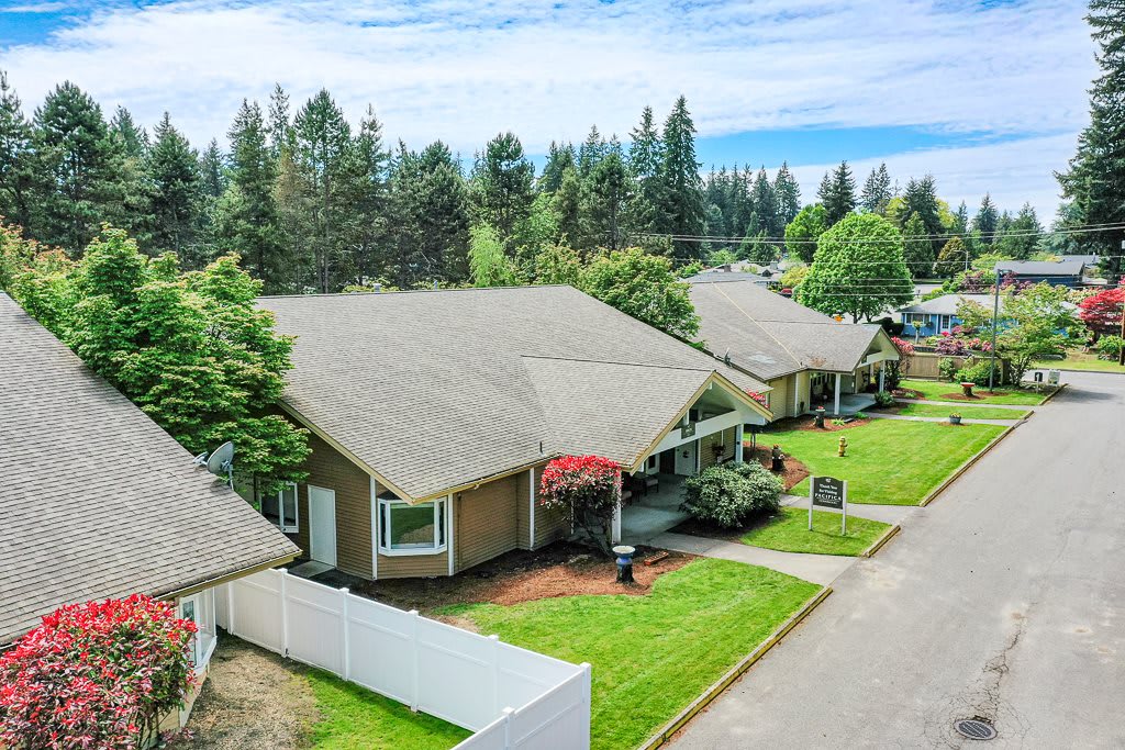 A suburban neighborhood with houses surrounded by trees and green lawns.