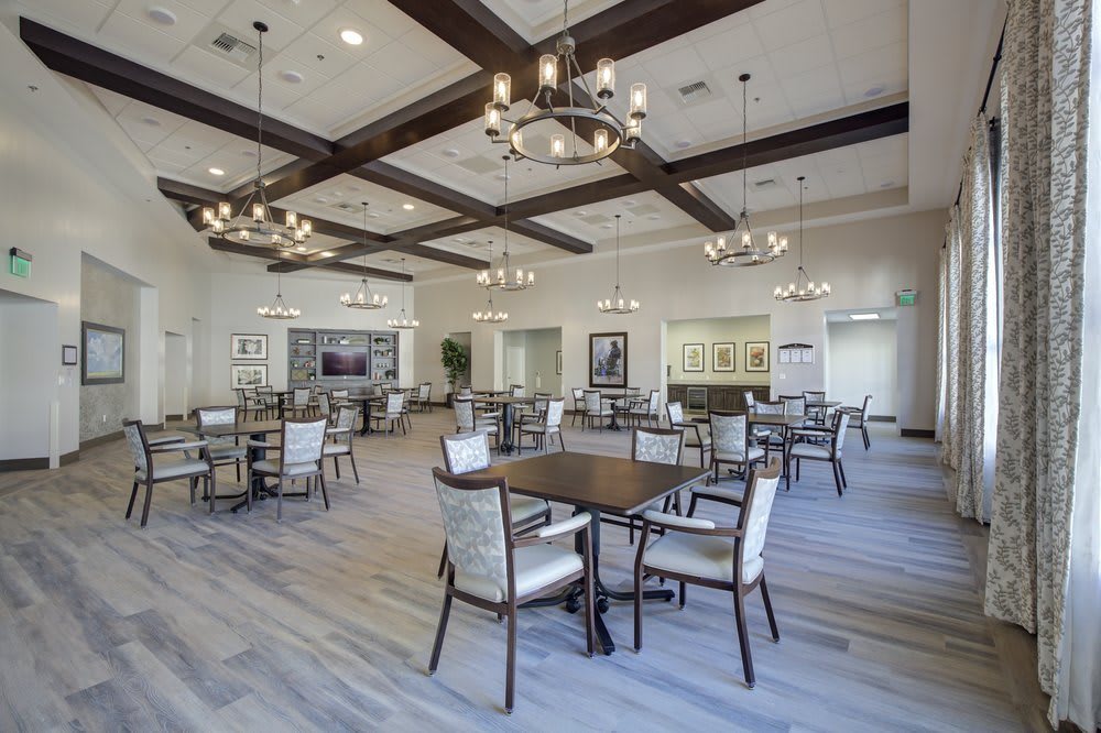 A modern dining room with elegant chandeliers and wooden beam decorations.