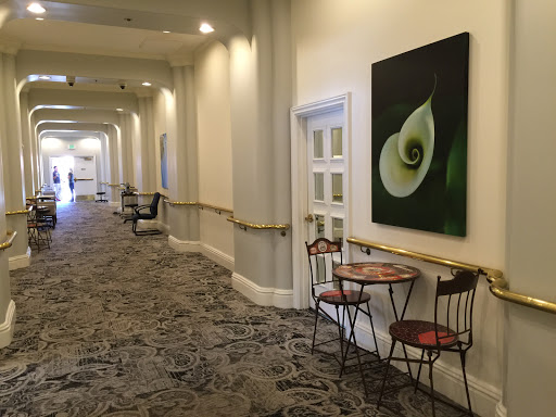A serene hallway featuring elegant artwork and a cozy seating area.