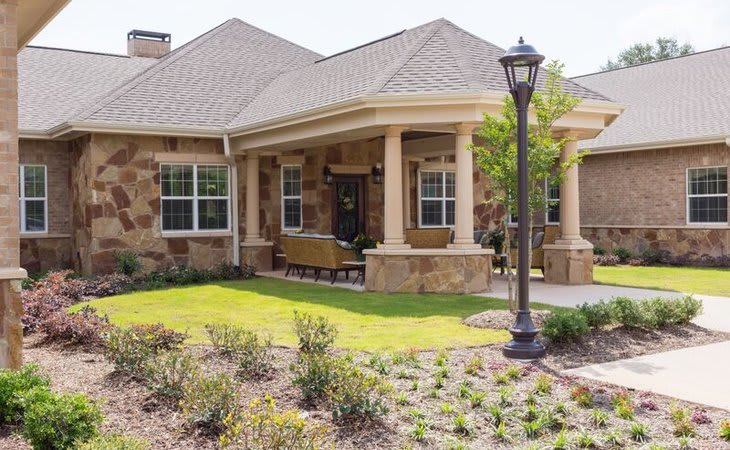 A charming residential house with a well-maintained front yard and a welcoming porch.