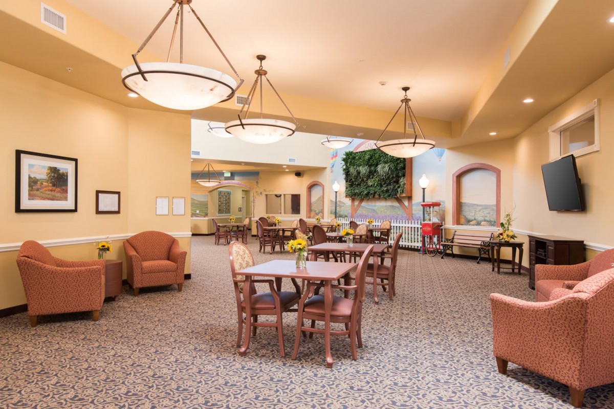 A spacious and well-lit dining area with wooden furniture and comfortable seating.