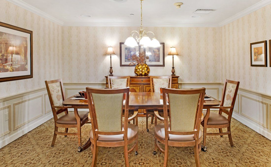 A traditional dining room with elegant furniture and lighting.
