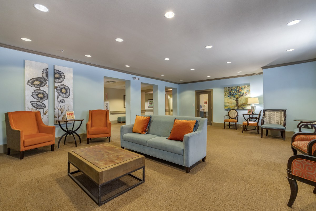 A cozy living room with a sofa and armchairs, featuring modern decor.
