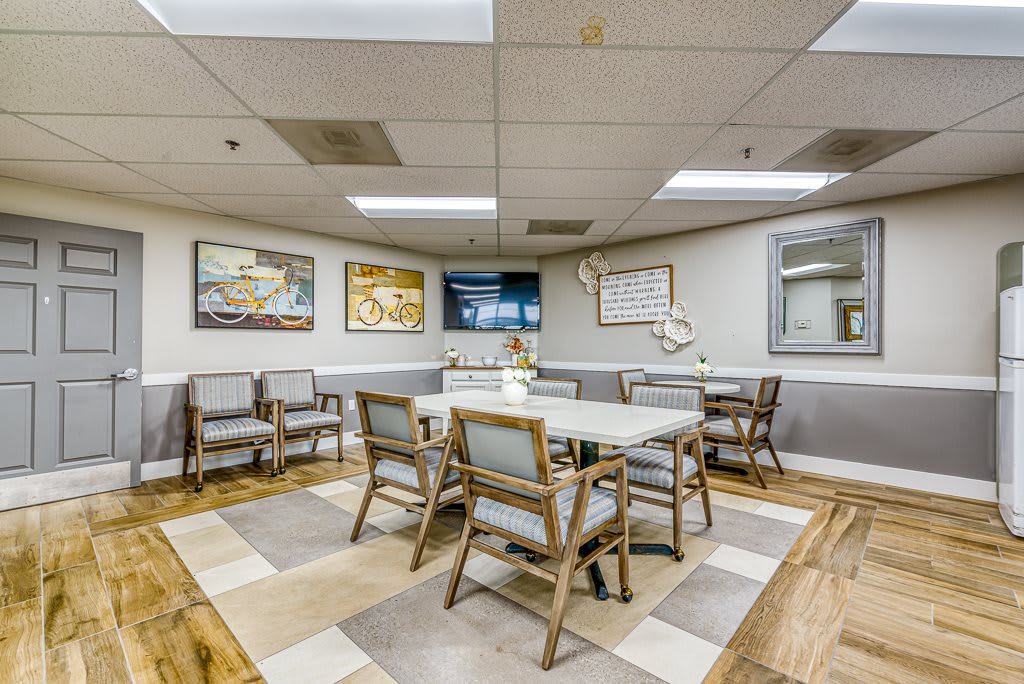 A well-lit meeting room with a central table, surrounded by chairs and decorated with wall art.