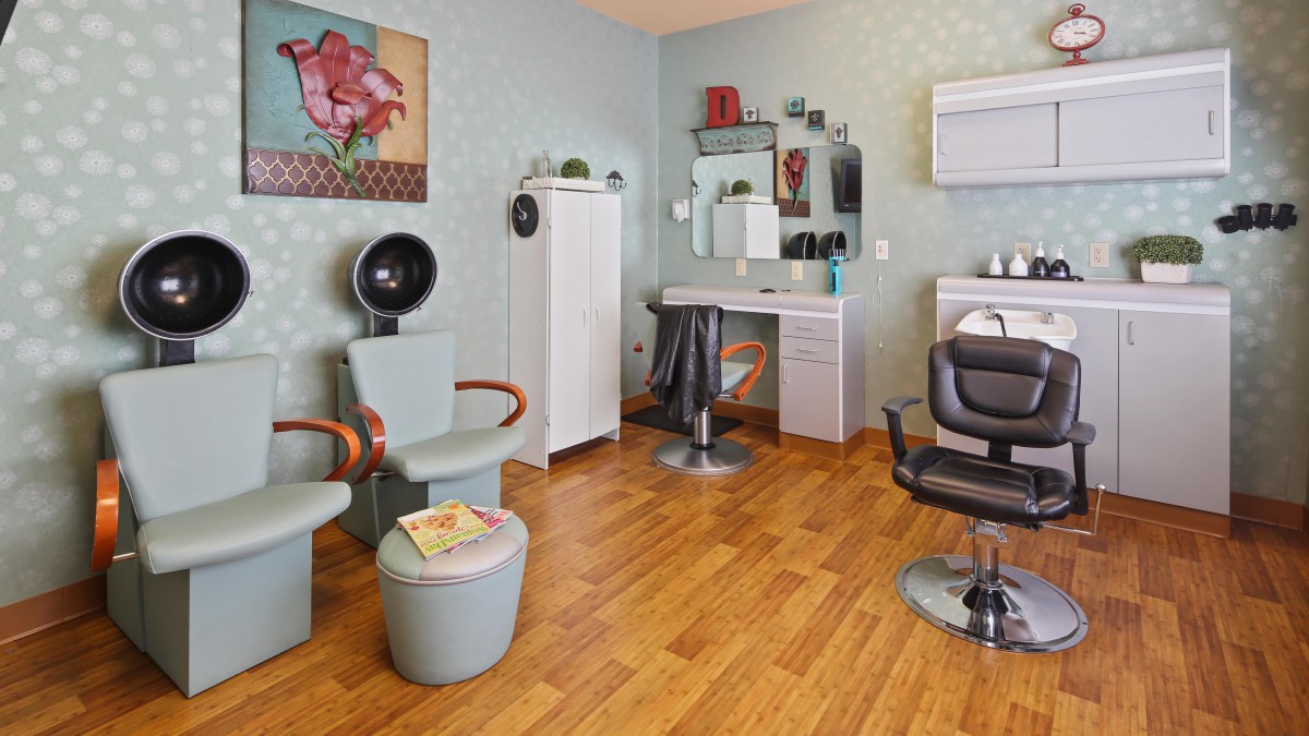A modern hair salon interior with chairs, a mirror, and a hair dryer.