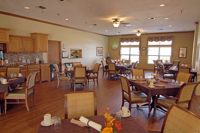 An empty dining room with neatly arranged tables and chairs.