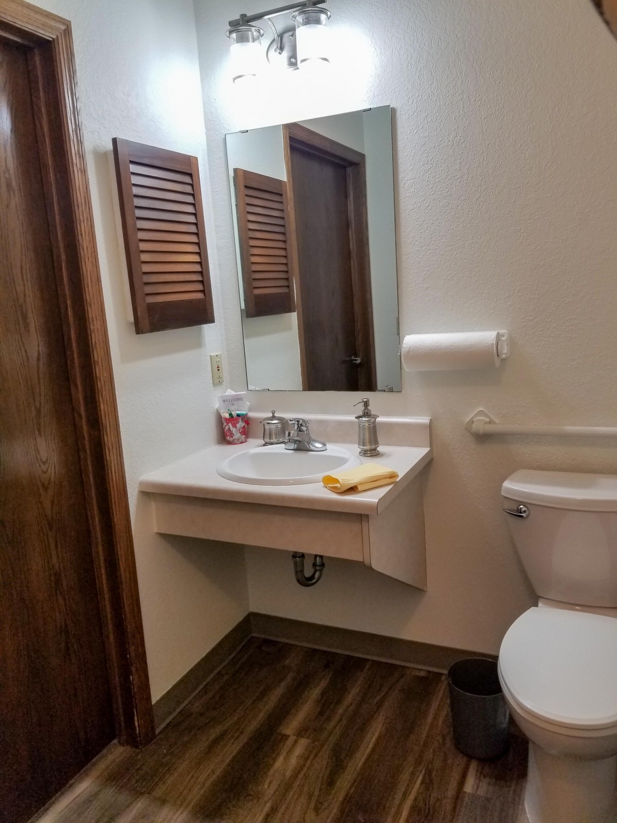 A small bathroom with a sink, mirror, and toilet.