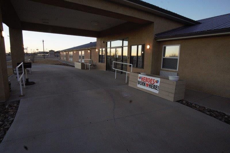 Exterior view of a building entrance with a covered walkway and ramp.