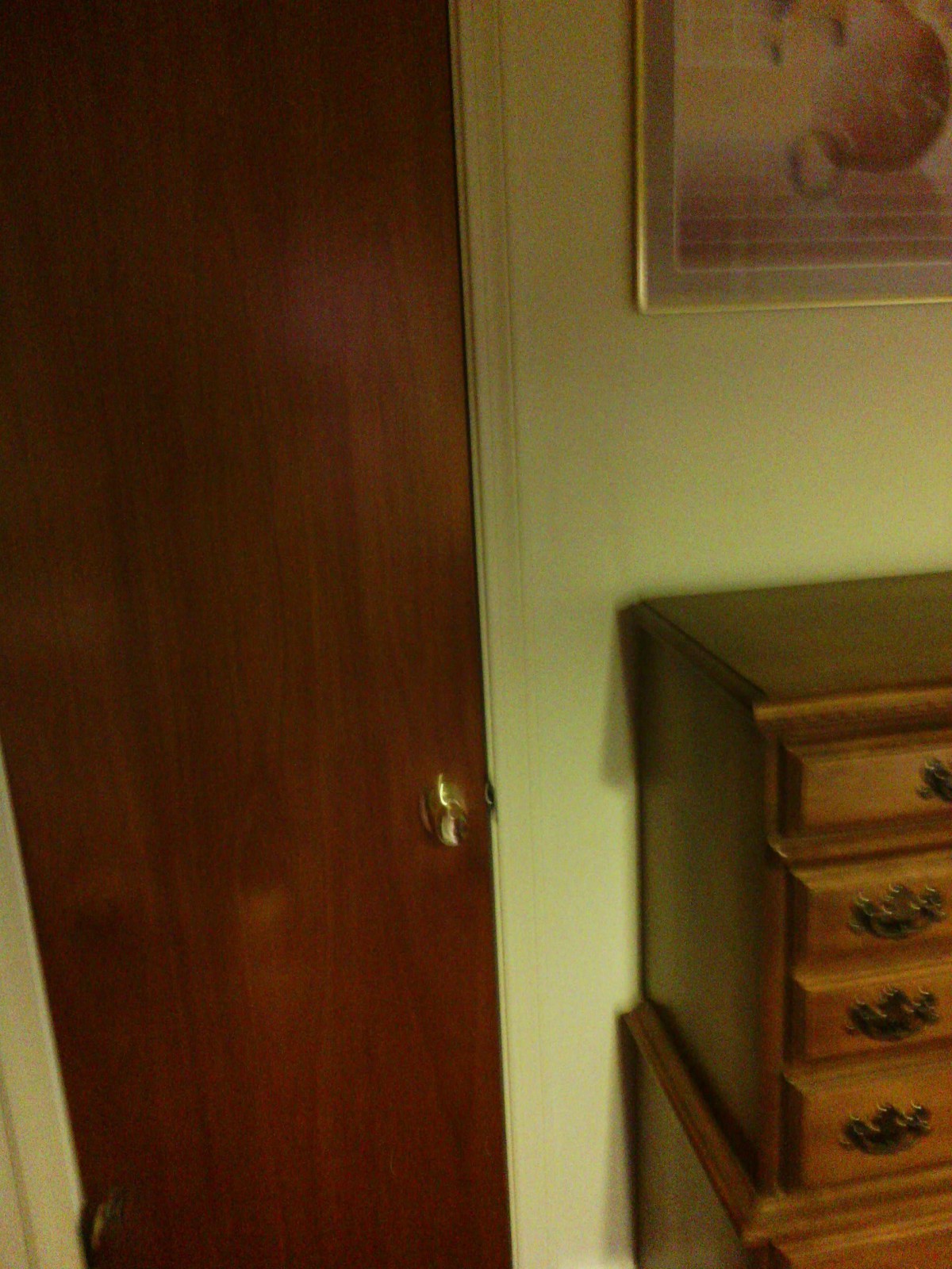 A room with a wooden door and a dresser.