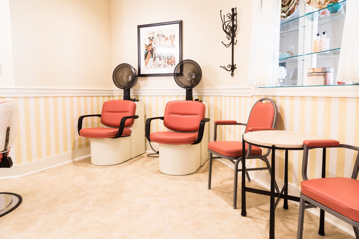 An empty salon with retro hair dryers and seating area.
