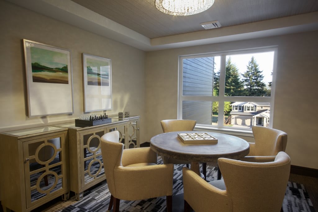 A cozy dining room with elegant furniture and large windows allowing natural light to fill the space.