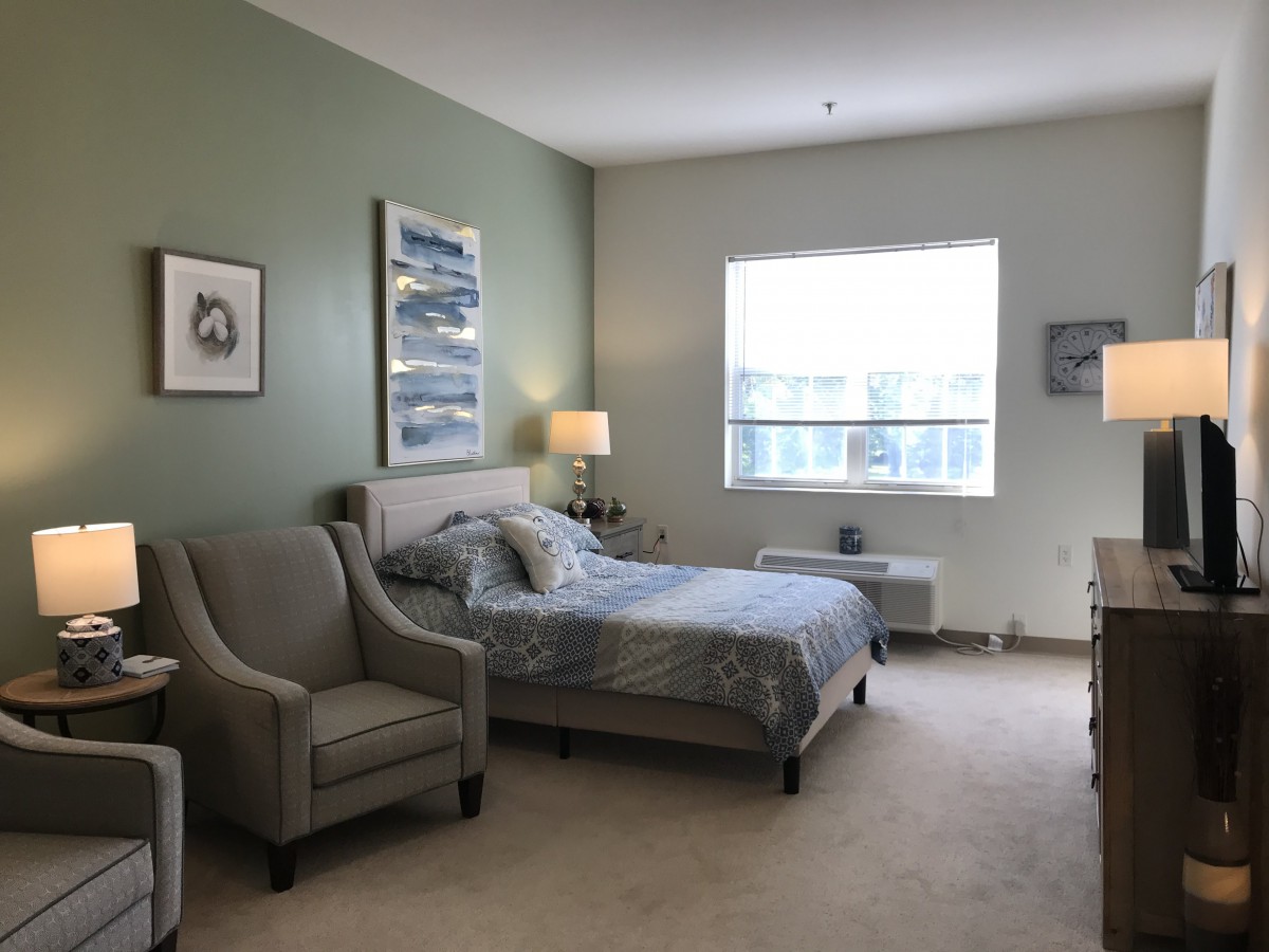 A cozy, well-decorated bedroom with a large bed, comfortable chairs, and soft lighting.