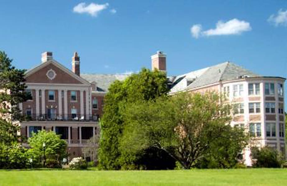 A large building on a campus surrounded by greenery and open space.