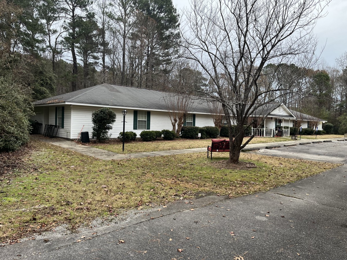 A suburban house with a driveway and surrounding lawn.