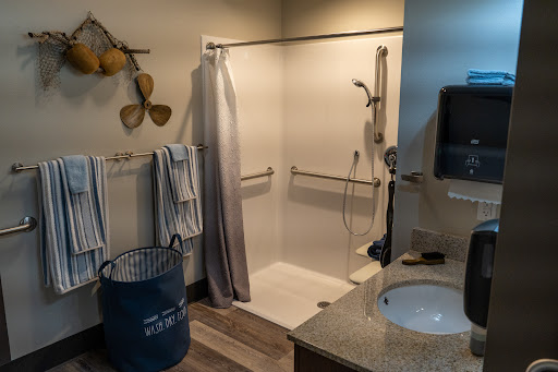 A modern bathroom featuring a shower space, towels neatly hung, and a stylish sink area.