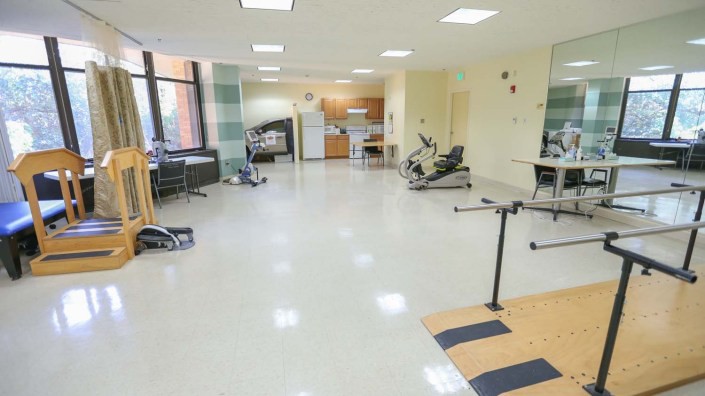 A rehabilitation room equipped with various exercise machines and tools for physical therapy.