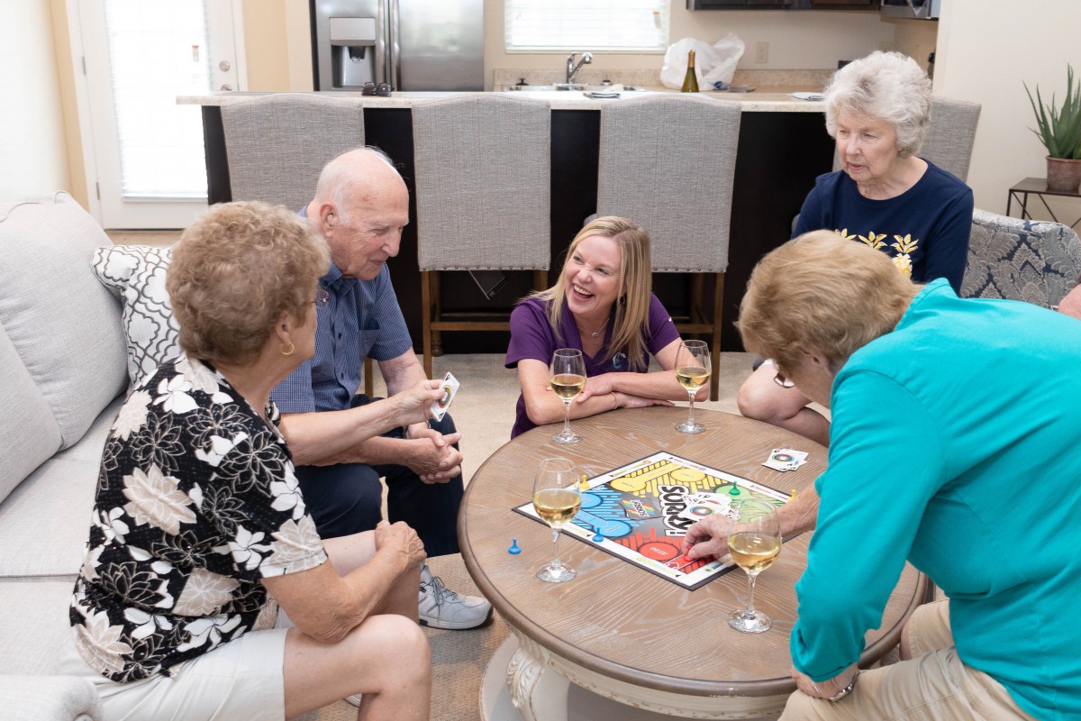 A group of people enjoying a board game together, sharing laughs and having fun indoors.