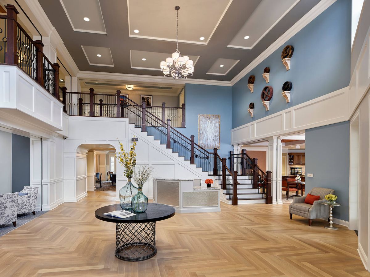 A spacious and elegantly designed foyer with a grand staircase and modern decor.