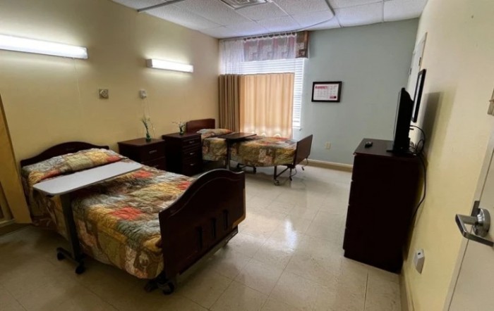 A clean and organized hospital room with patient beds and essential furnishings.