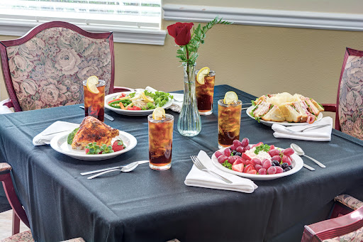 A beautifully arranged table featuring a delicious meal, complete with drinks and fresh flowers.