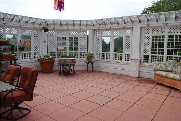 A spacious outdoor terrace with potted plants and a lattice pergola.