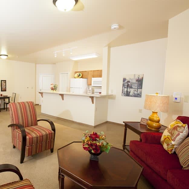 A cozy living room with comfortable seating and a view into the kitchen area.