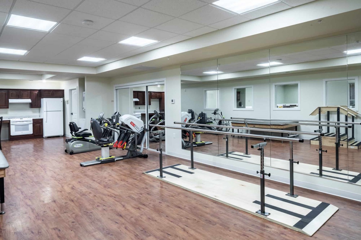 A fitness studio with exercise equipment and mirrored walls.