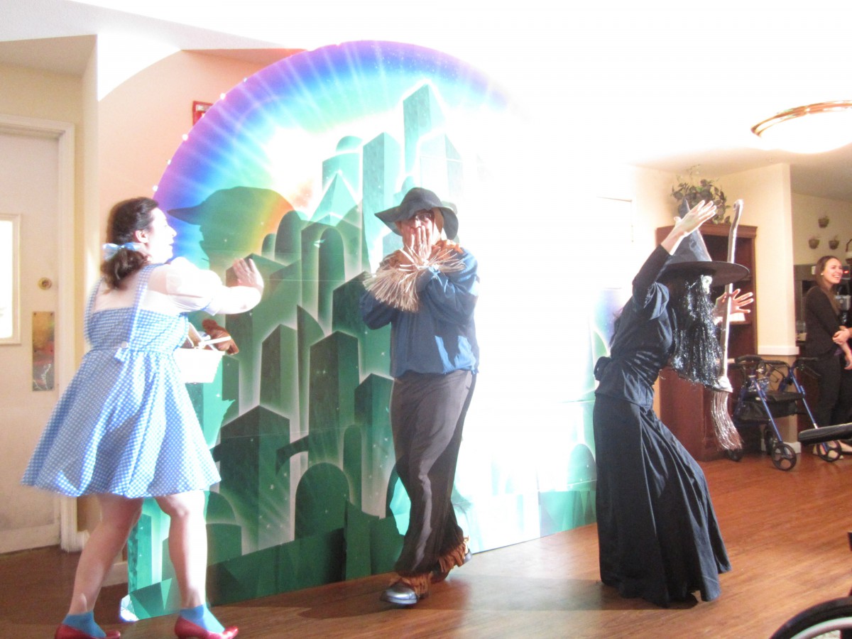 A group of people in costumes performing a scene with colorful props.