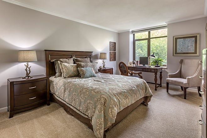 A cozy bedroom with elegant decor, featuring a comfortable bed and a work desk by the window.