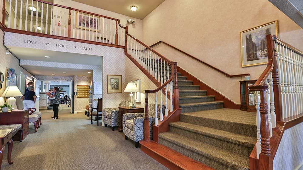 A traditional hallway with a staircase and seating area.