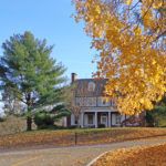 A charming house surrounded by vibrant autumn foliage.