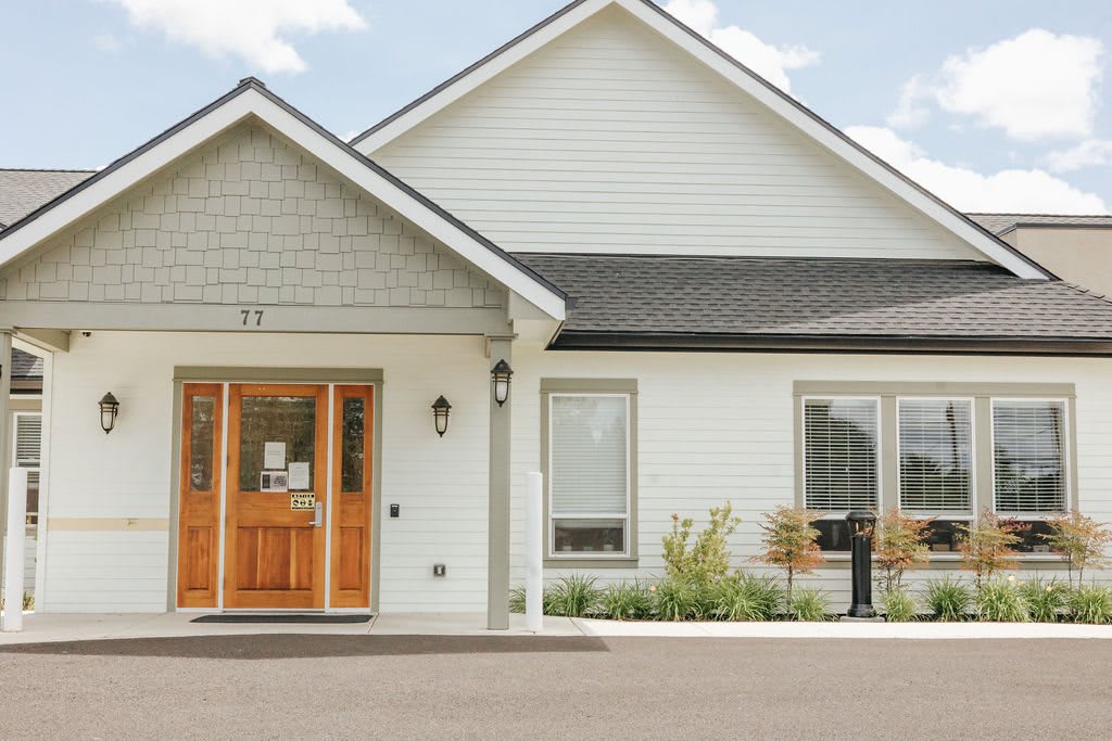 A charming residential house with a light exterior and wooden front door.
